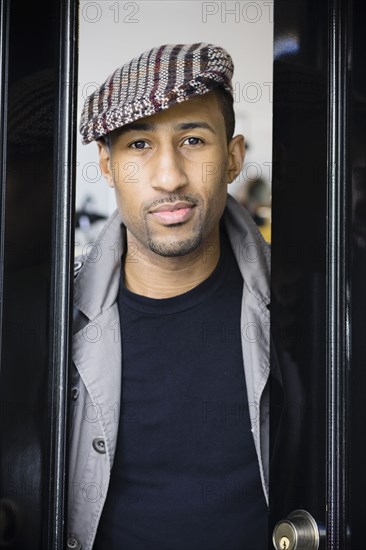 African American man wearing coat and cap