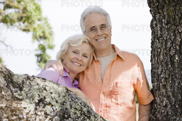 Caucasian couple posing near tree