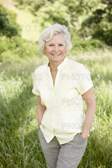Caucasian woman in field with hands in pockets