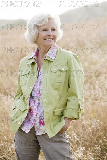 Caucasian woman in field with hands in pockets
