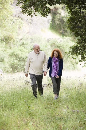 Caucasian couple walking in woods