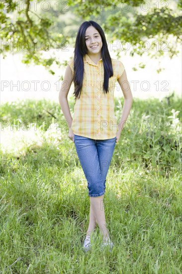 Hispanic girl standing in field