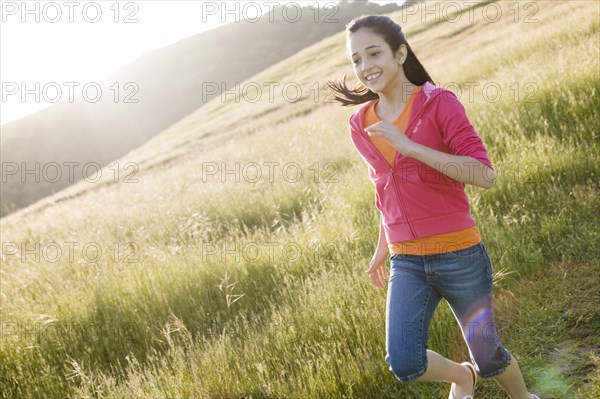 Hispanic girl running in field