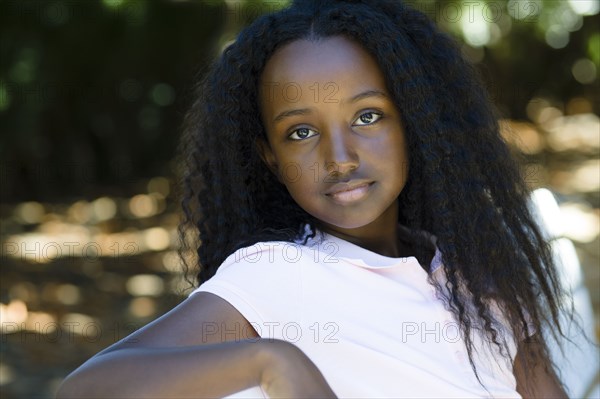 Serious Black girl sitting in park