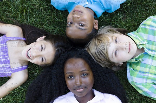 Children laying in formation on grass