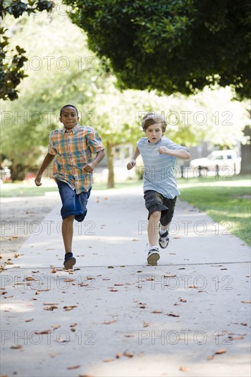 Boys running on sidewalk