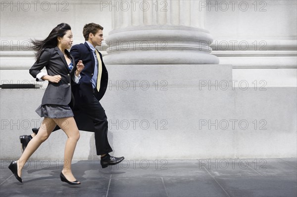 Business people running on sidewalk