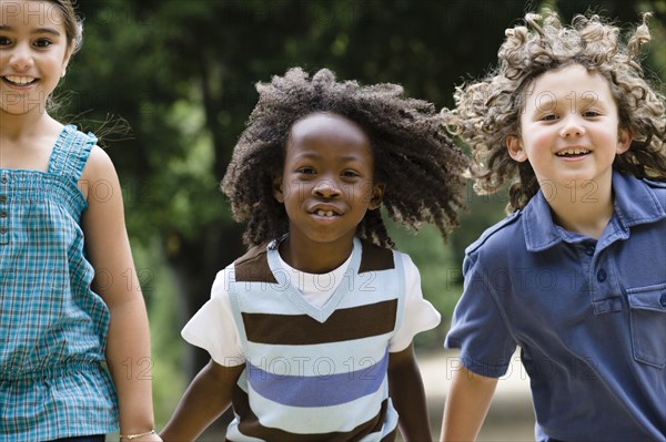 Smiling children holding hands and running