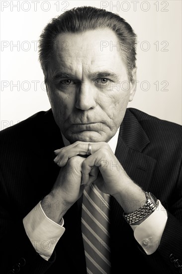 Serious Caucasian businessman with hands on chin
