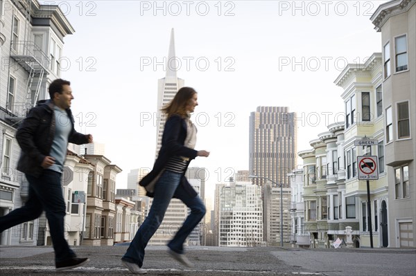 Caucasian couple crossing city street