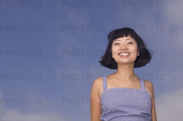 Portrait of Asian woman under blue sky