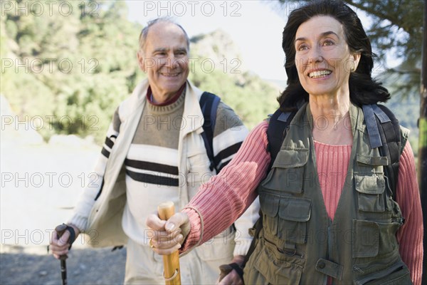 Senior couple hiking with poles