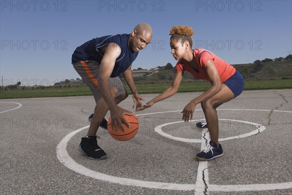 African man and woman playing basketball