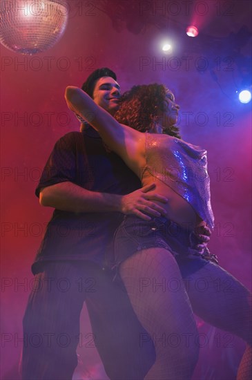 Multi-ethnic couple dancing at nightclub