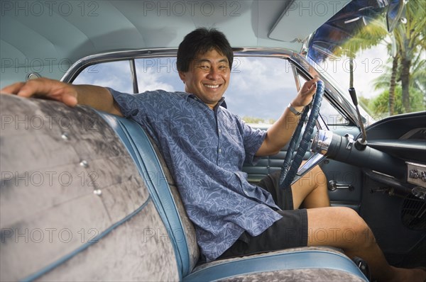 Asian man sitting in car