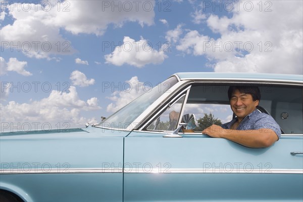 Asian man sitting in car