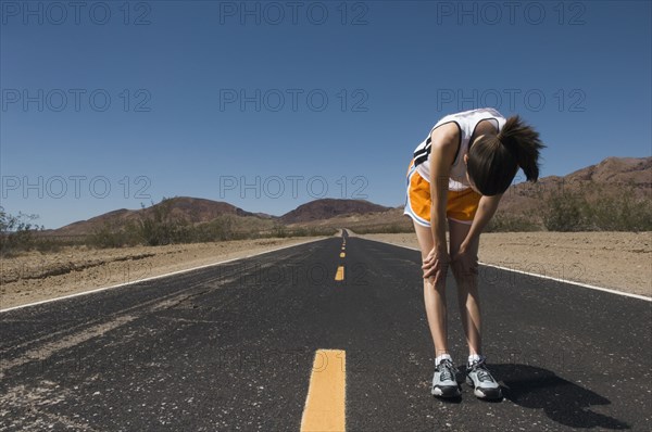 Mixed Race female runner stretching