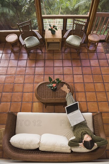 High angle view of woman using laptop on sofa