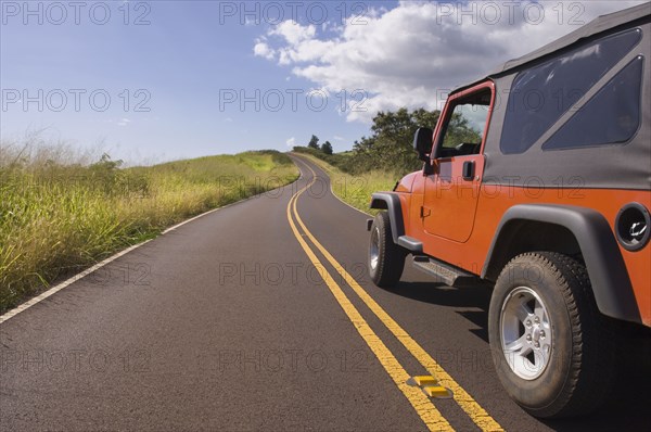 4x4 driving on remote road under blue sky