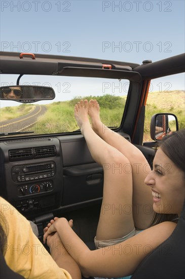 Hispanic woman holding boyfriend's hand in jeep