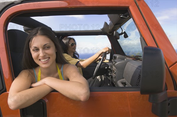 Hispanic woman leaning out window of jeep