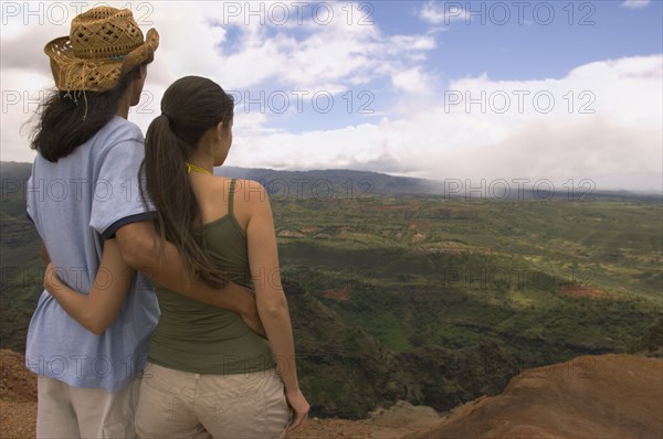 Couple hugging and looking out over landscape