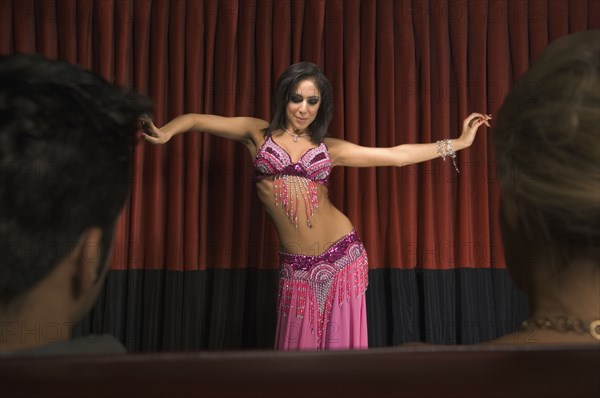 Middle Eastern woman belly dancing on stage