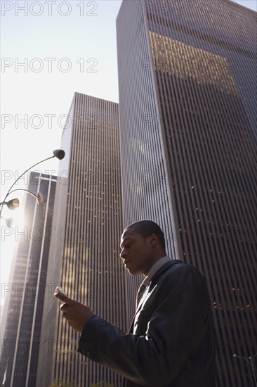 African American businessman looking at cell phone