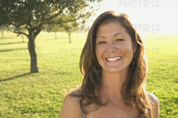 Portrait of woman in sunlit meadow