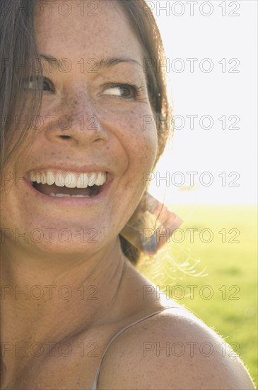 Portrait of woman in sunlit meadow