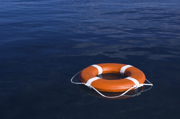 Round life preserver floating in water