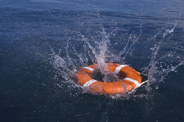 Round life preserver splashing into water