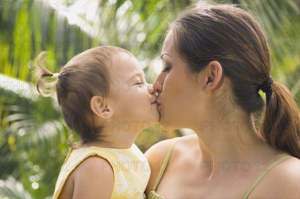 Hispanic mother kissing baby