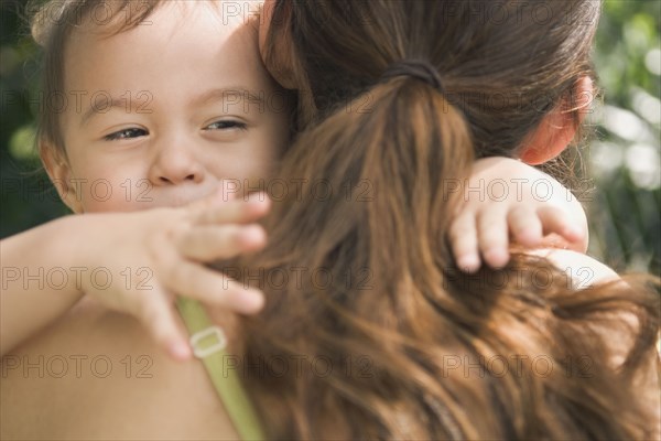 Hispanic baby hugging mother