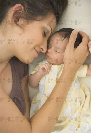 Hispanic mother laying next to baby