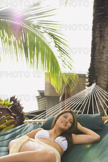 Asian woman laying in hammock