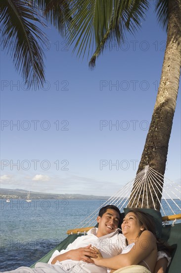 Multi-ethnic couple laying in hammock