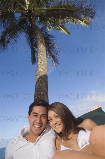 Multi-ethnic couple laying in hammock