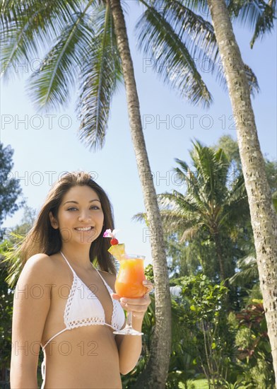 Asian woman holding cocktail