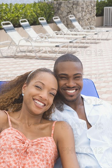 African American couple laying on lounge chair