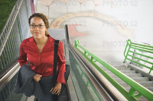 African businesswoman on escalator