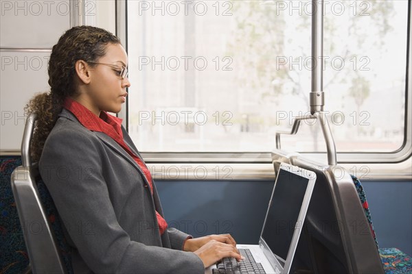 African businesswoman working on train