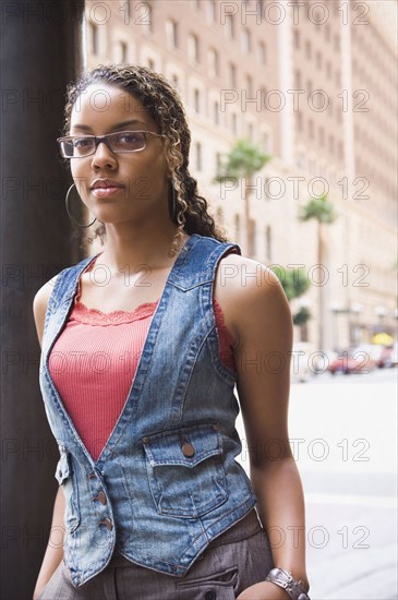 African woman leaning on street post