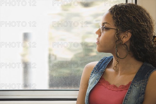 African woman looking out train window