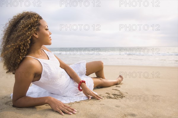 African woman laying on sand