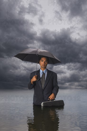 Hispanic businessman standing in water