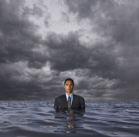 Hispanic businessman standing in water