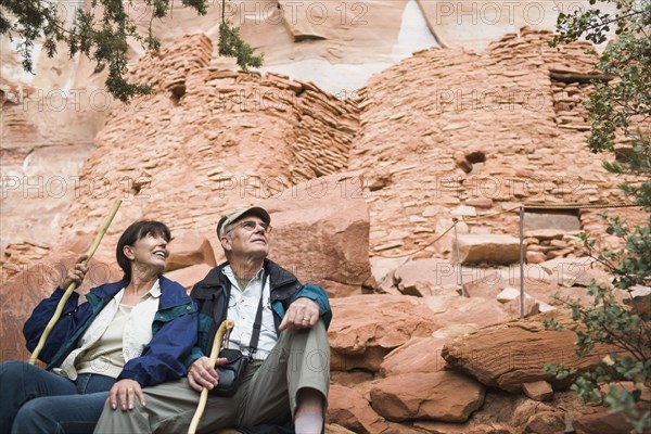 Multi-ethnic senior couple holding walking sticks