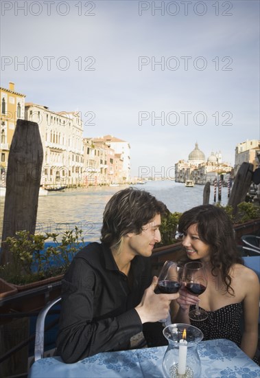 Italian couple drinking red wine at sidewalk cafe