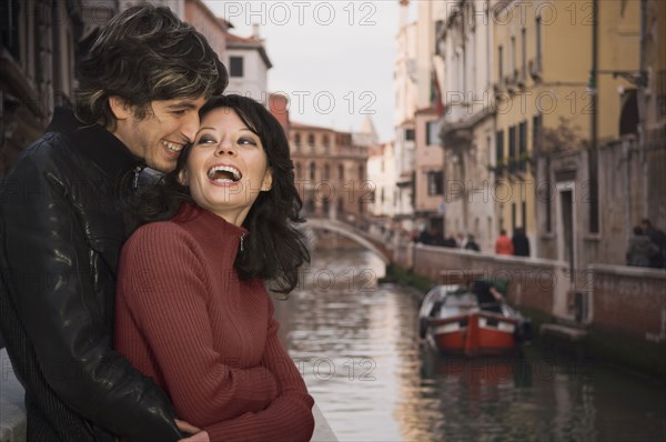 Italian couple hugging near canal